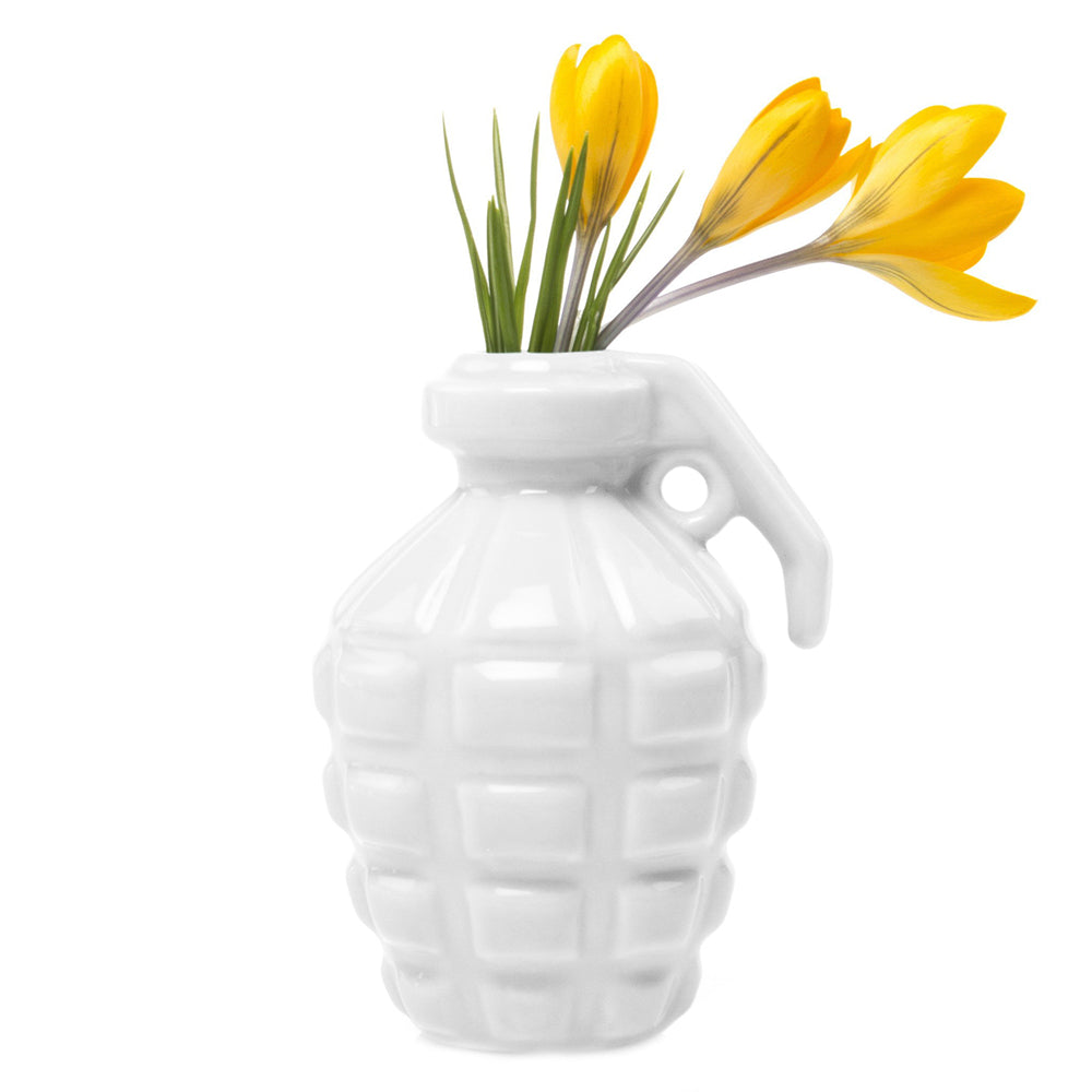 A white Kapow Ceramic Grenade Flower Vase Unique, designed by Chive Studio 2024, holding a small bouquet of yellow crocus flowers, isolated on a white background.